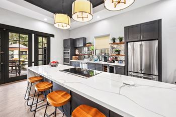 Contemporary kitchen with white waterfall island and pendant lighting