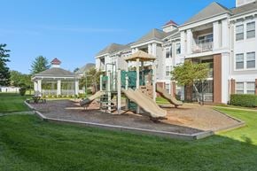 Waldorf apartment for rent - A playground with a slide and a gazebo in front of a building.