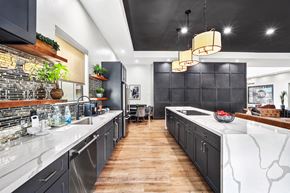 Phoenix apartment for rent - Modern kitchen with dark cabinets and white marble countertops at ReNue Downtown Apartments, Phoenix, AZ 85007
