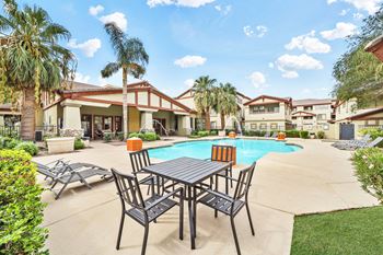 Outdoor pool deck with dining table and palm trees