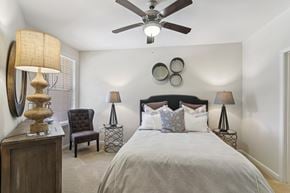 Kennesaw apartment for rent - A bedroom with a bed, chair, and ceiling fan.