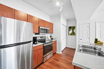 Galley kitchen with stainless steel appliances and wooden cabinetry