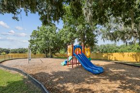Plant City apartment for rent - A playground with a blue slide and a yellow slide.
