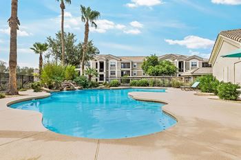 Large freeform pool with surrounding deck and lounge chairs