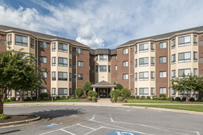 Waldorf apartment for rent - A large apartment complex with a parking lot in front.