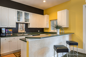 Sanford apartment for rent - a kitchen with white cabinets and a yellow wall