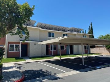 Parlier apartment for rent - A building with a parking lot in front of it.