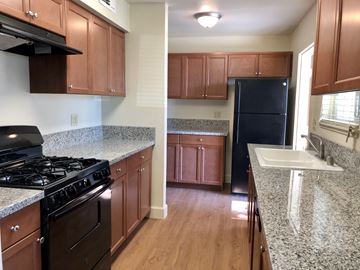 Fresno apartment for rent - A kitchen with a black fridge and a black stove.