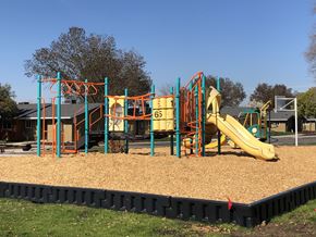 Fresno apartment for rent - A playground with a yellow slide and a green and orange structure.