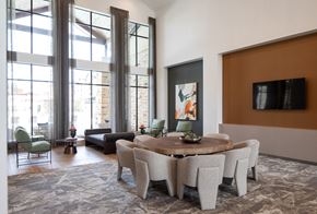 Fulshear apartment for rent - a living room with large windows and a large round table with chairs