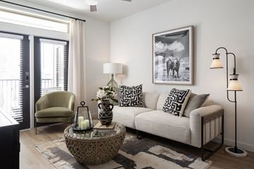Fulshear apartment for rent - A living room with a sofa, chair, and a table with a vase and candles on it.
