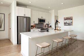 Brookshire apartment for rent - a kitchen with white cabinets and a large island with three stools