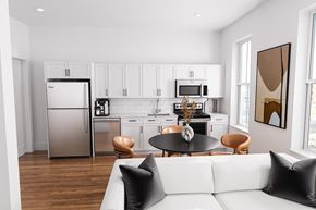 Bay Shore apartment for rent - A modern kitchen with a white refrigerator and a white couch with black pillows.
