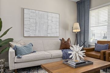 Wilmington apartment for rent - A living room with a grey couch, a coffee table, and a large abstract painting on the wall.