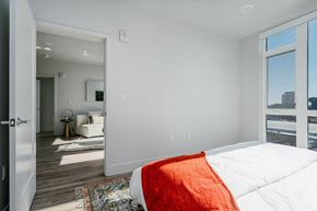 Oakland apartment for rent - A bedroom with a large bed and a view of the city.