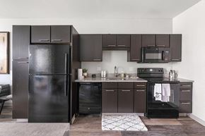 Pittsburgh apartment for rent - a kitchen with a black refrigerator freezer next to a stove top oven