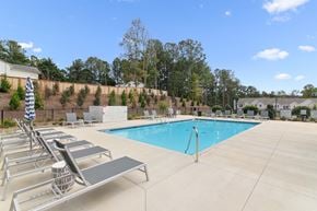 Flowery Branch townhouse for rent - the swimming pool at our apartments with chairs and a pool