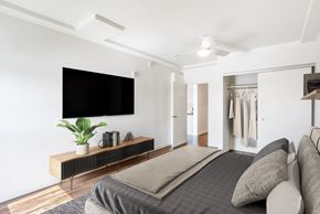 Oakland apartment for rent - A modern bedroom with a large bed and a flat screen TV mounted on the wall.
