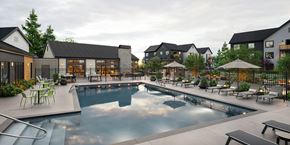 University Place apartment for rent - A large outdoor swimming pool surrounded by lounge chairs and umbrellas.