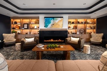 Denver apartment for rent - A modern living room with a fireplace and a large painting on the wall.