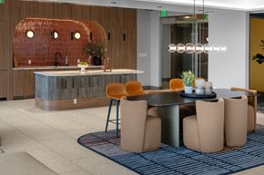 Denver apartment for rent - A modern dining area with a round table and orange chairs.