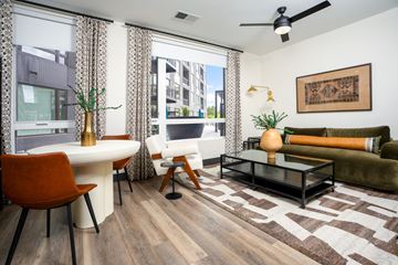 Denver apartment for rent - A living room with a brown rug and a white table.