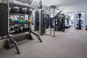 Santa Ana apartment for rent - A gym with a variety of equipment including dumbbells, weight plates, and cardio machines.