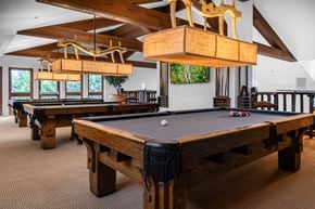 Santa Ana apartment for rent - A pool table in a room with wooden furniture and a light brown carpet.