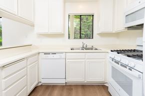 Santa Ana apartment for rent - a kitchen with white cabinets and appliances and a sink