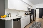 Seattle apartment for rent - A modern kitchen with white cabinets and stainless steel appliances.