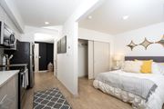 Seattle apartment for rent - A modern bedroom with a large bed and a kitchen area.