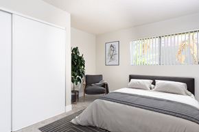 Anaheim apartment for rent - A bedroom with a large bed and a chair.