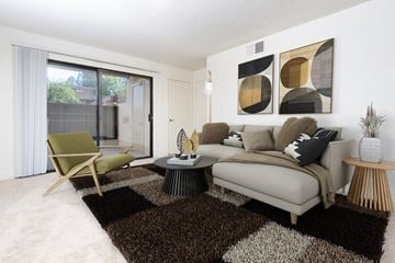 Azusa apartment for rent - A living room with a couch, chair, and two abstract paintings on the wall.