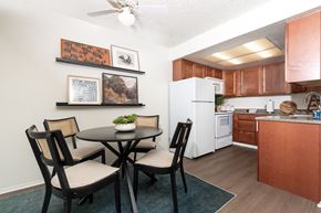 Azusa apartment for rent - A kitchen with a table and chairs in the foreground and a refrigerator in the background.