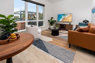 Bellevue apartment for rent - A living room with a brown couch, a wooden table, and a painting on the wall.
