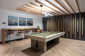Bellevue apartment for rent - A pool table is in the middle of a room with a bar and pictures on the wall.