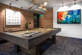 Redmond apartment for rent - A pool table with a green plant and a painting on the wall.
