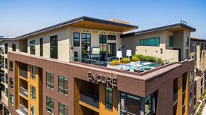 Redwood City apartment for rent - a large apartment building with a rooftop terrace and a pool