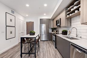 Redwood City apartment for rent - a modern kitchen with stainless steel appliances and a table with chairs