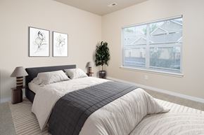 Arvada apartment for rent - A bedroom with a large bed and two framed pictures on the wall.