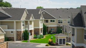 Arvada apartment for rent - A view of apartment buildings with a small gazebo in the front.
