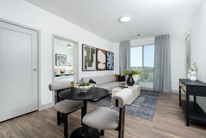 Aurora apartment for rent - A modern dining room with a round table and grey chairs.
