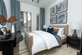 Aurora apartment for rent - A bedroom with a large bed and a painting above it.