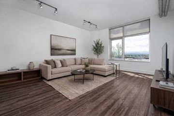 Denver apartment for rent - A living room with a large couch and a painting on the wall.