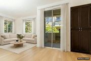 Cupertino apartment for rent - A living room with a white couch, a coffee table, and a glass door leading to a balcony.