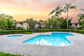 Santa Ana apartment for rent - a swimming pool with palm trees and buildings in the background