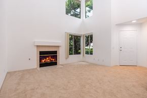 Santa Ana apartment for rent - an empty living room with a fireplace and windows