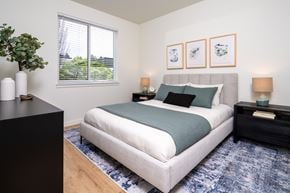 University Place apartment for rent - A bedroom with a large bed and a black dresser.