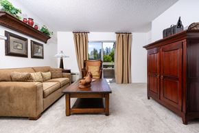 San Ramon apartment for rent - A living room with a brown couch, a wooden coffee table, and a brown cabinet.