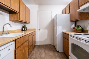San Ramon apartment for rent - A kitchen with wooden cabinets and white appliances.